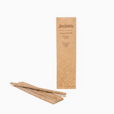 Six grey copal hand rolled incense sticks next to branded packaging.