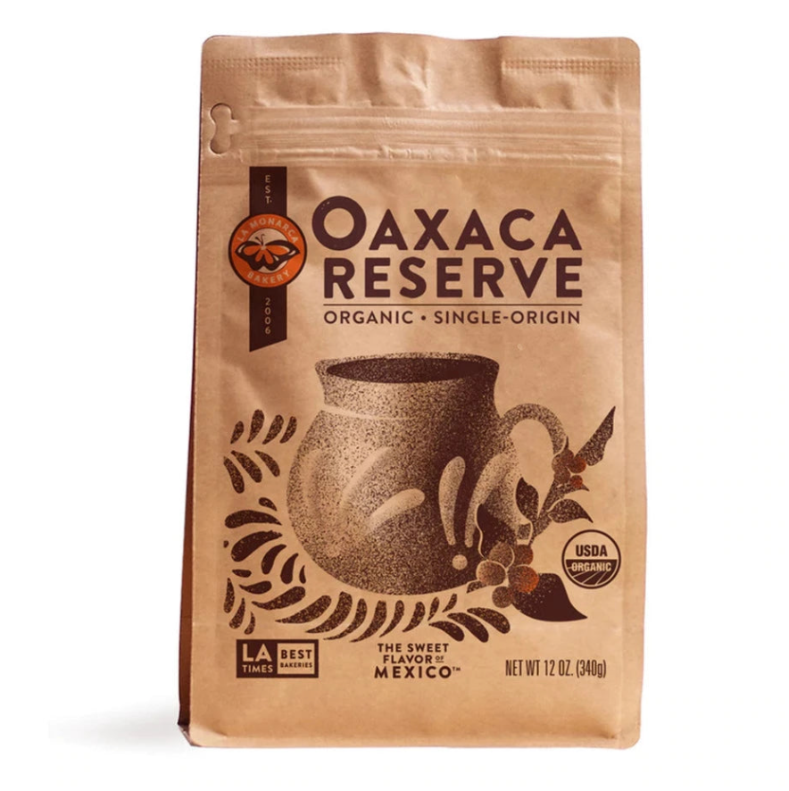 Front view of La Monarca Oaxaca Reserve Coffee in brown branded paper packaging with ziploc style closure