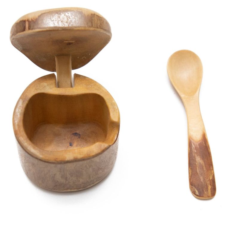 small round wood box with lid sitting adjacent to wood spoon