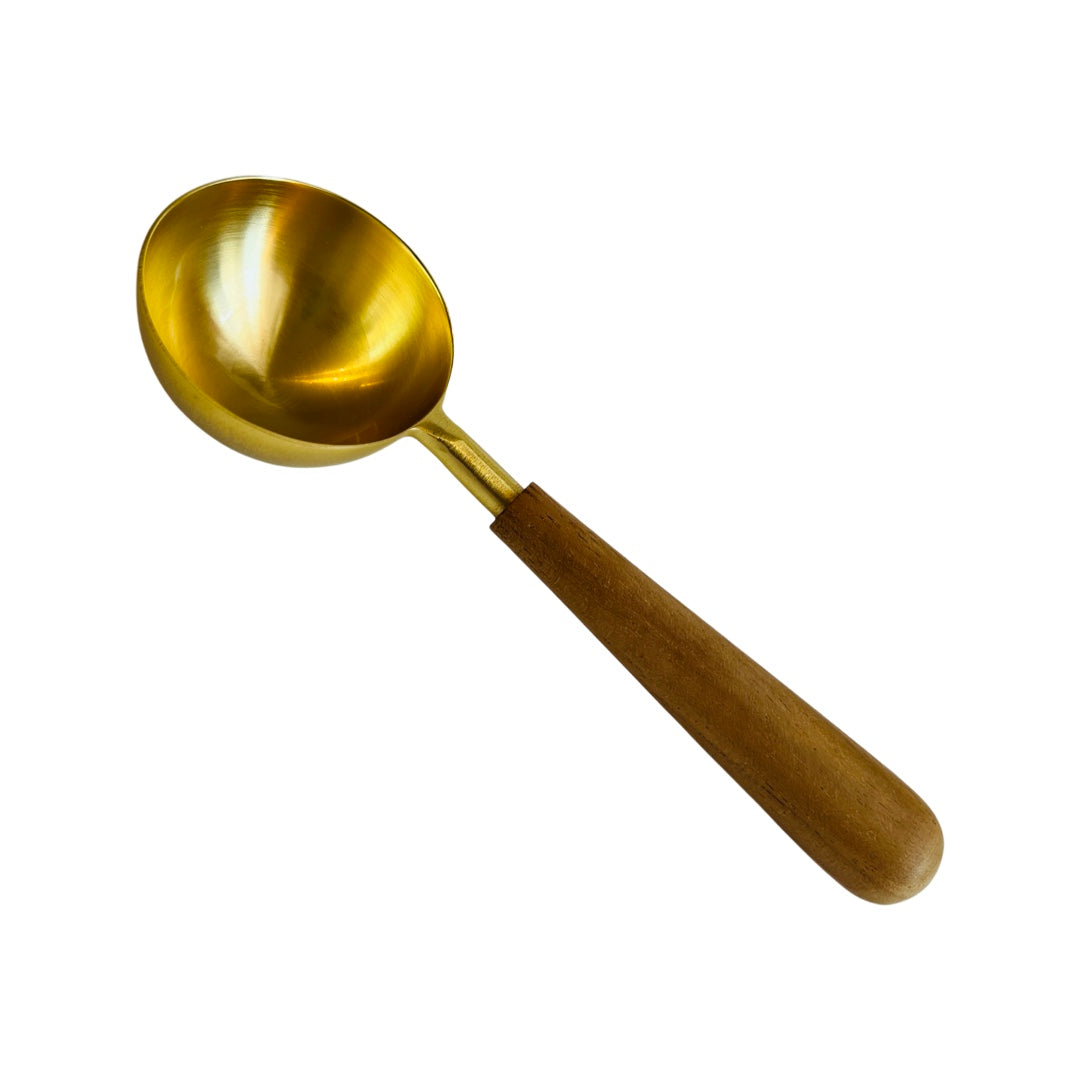 gold colored metal scoop with wood handle