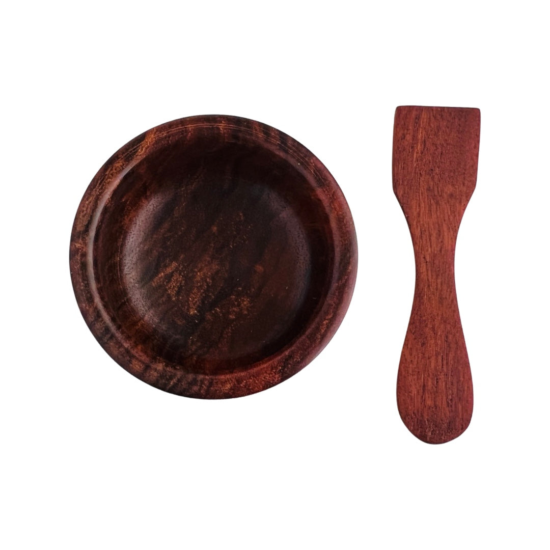 top view of circular bowl carved from wood with wooden spoon