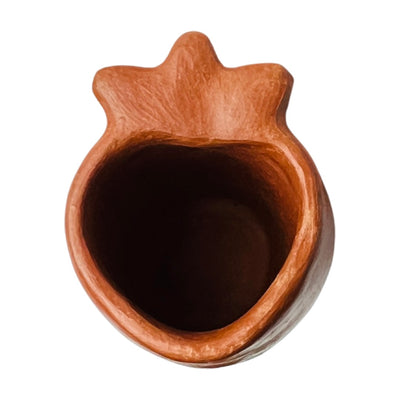 top view of a red clay shot glass with a heart design