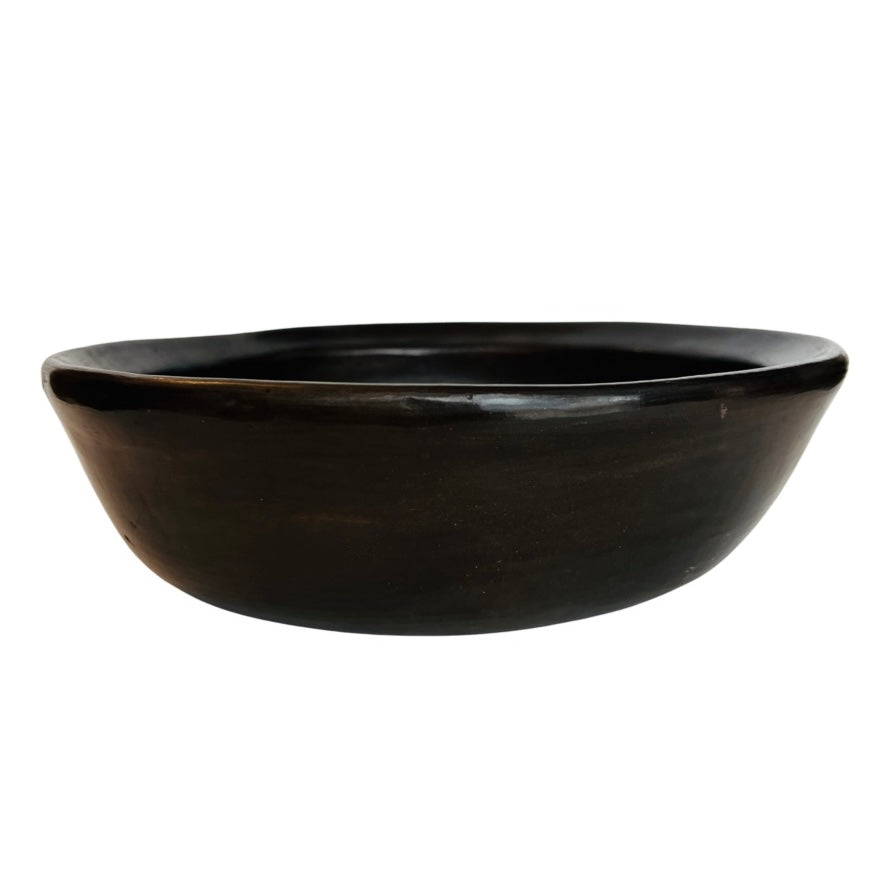Side view of a dark brown clay bowl
