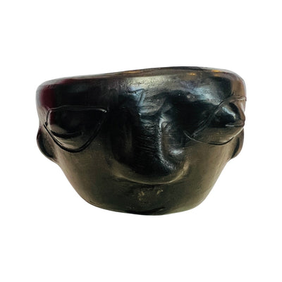 black clay shot glass featuring a face