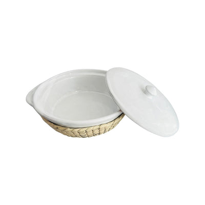 Side view of a white glazed barro casserole dish with its lid open and a palm leaf cover. 