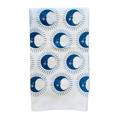 Half folded white towel with a pattern of blue quarter moons