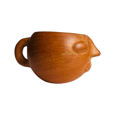 side view of red clay colored mug hand sculpted with facial features