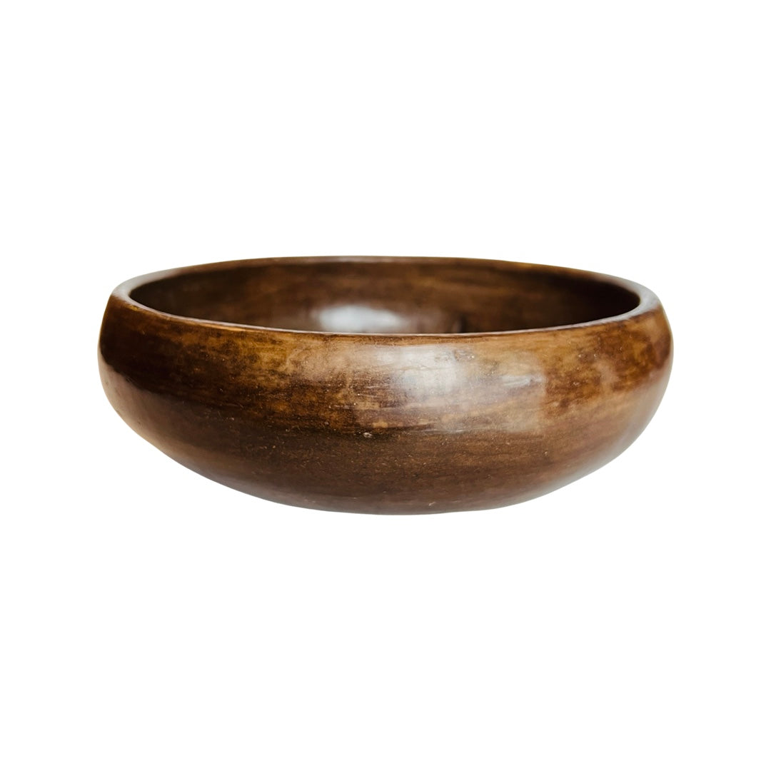 Side view of a medium brown clay bowl