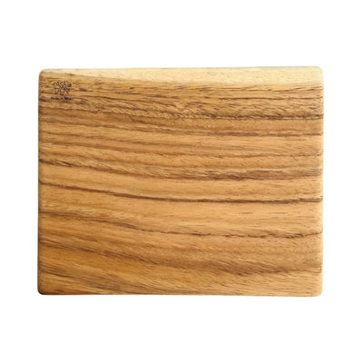 Top view of a rectangular wooden cutting board with the phrase Casa Y Cocina engraved on the top left corner.  Translation for Casa y Cocina is Home and Kitchen. 